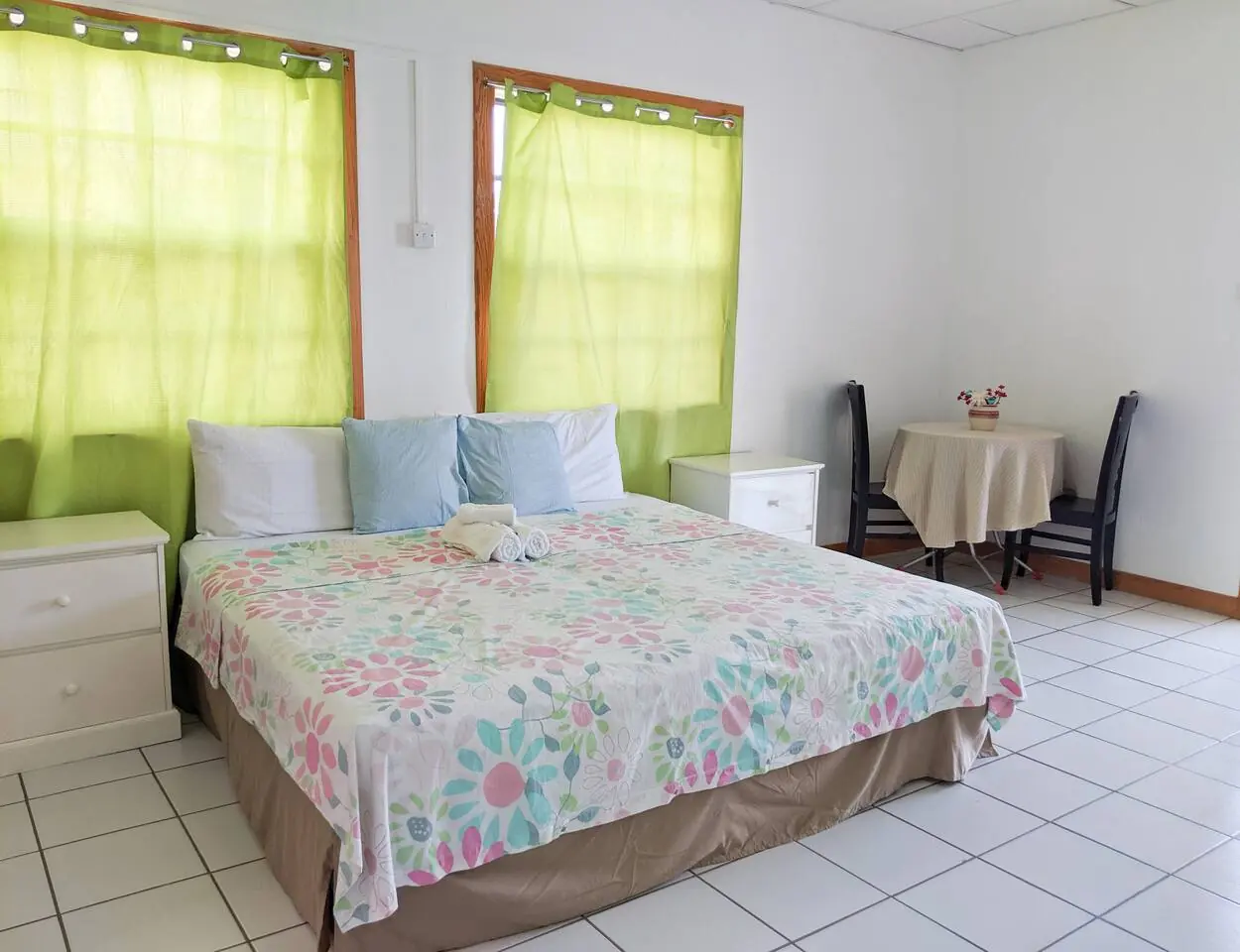 Bedroom with floral bedspread and green curtains