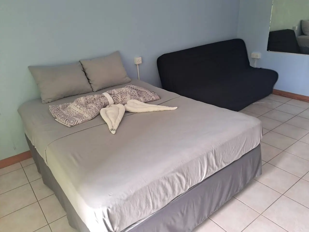 Bed with towel decoration and sofa