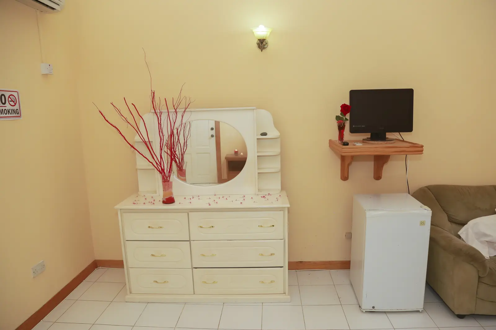 Dresser, mini-fridge and TV in a guest room